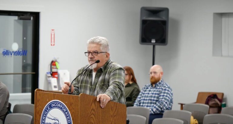 a resident stands at a podium during a waterville city council meeting.
