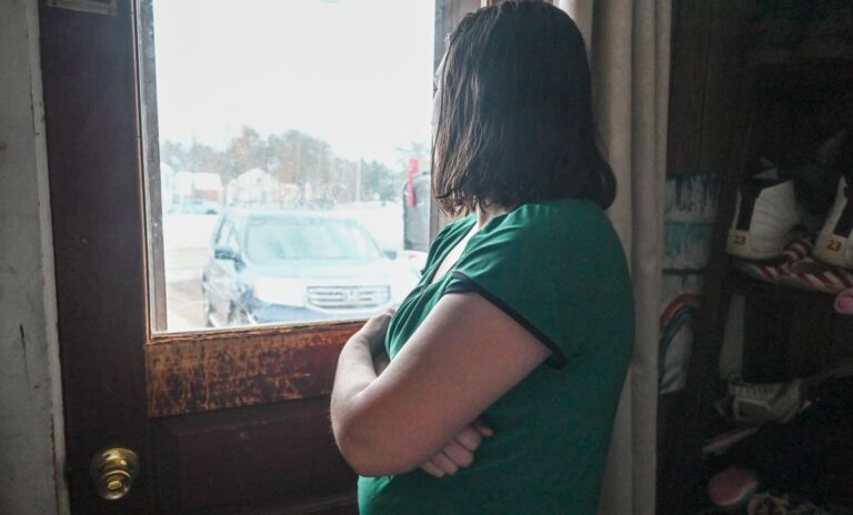 a woman looking out the window of a home.