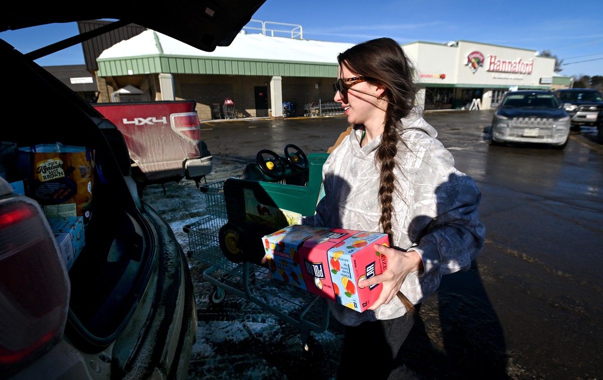 a woman loads groceries into her car.