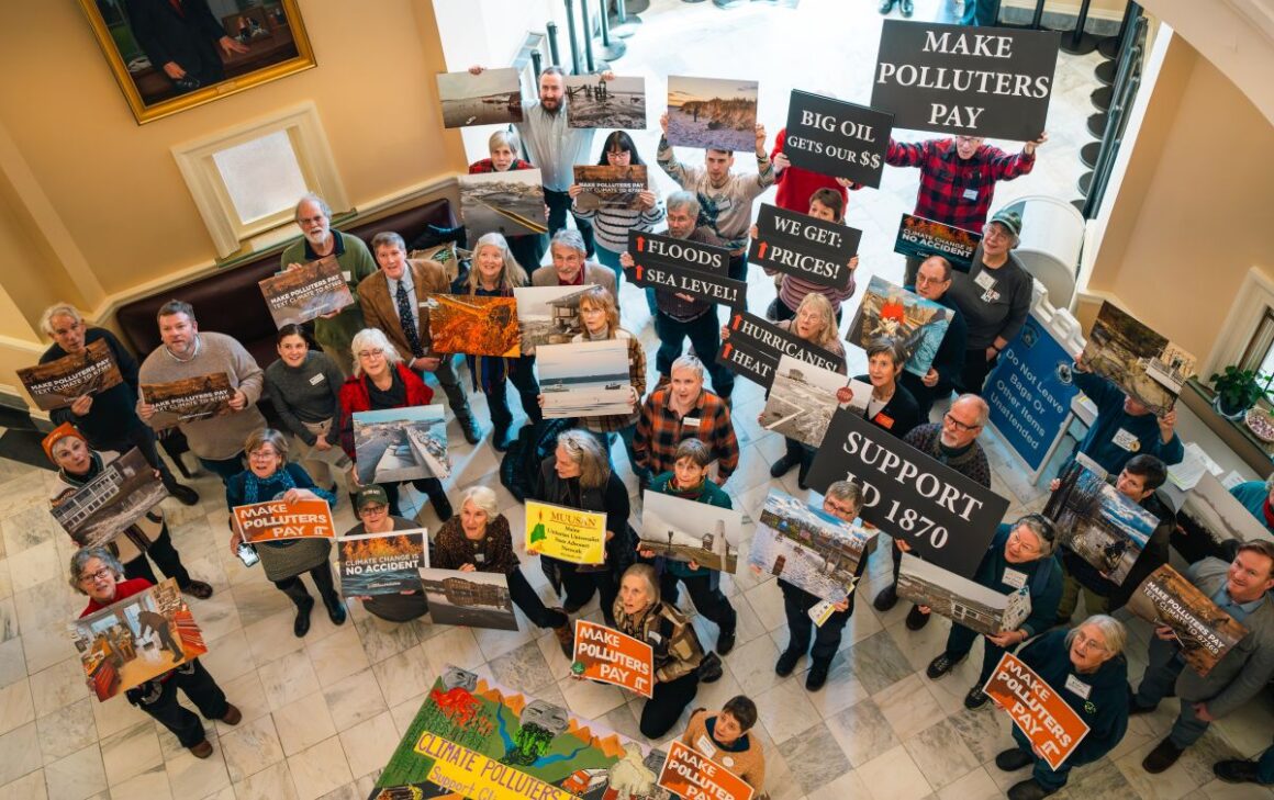 people gather in the statehouse with signs in support of LD 1870.