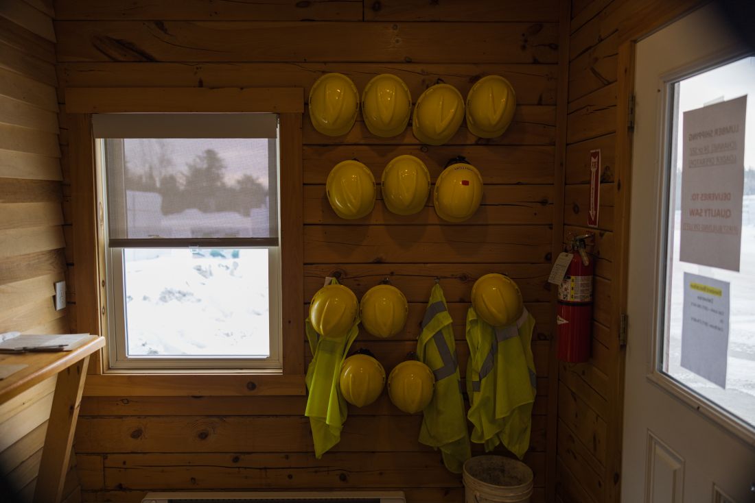 hard hats on the wall of a lumber yard.
