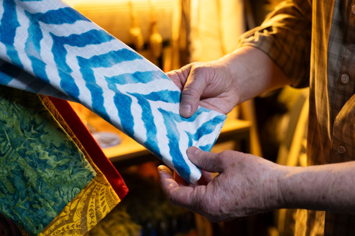 hand touching a blue and white cloth.