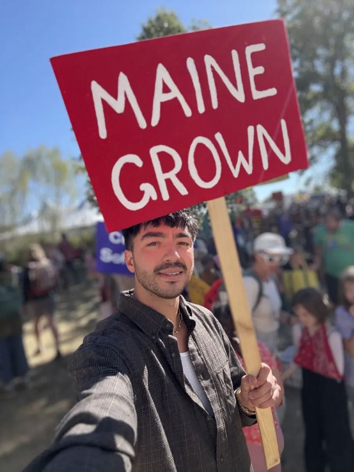 Sean Oshima holding a sign that reads Maine Grown.