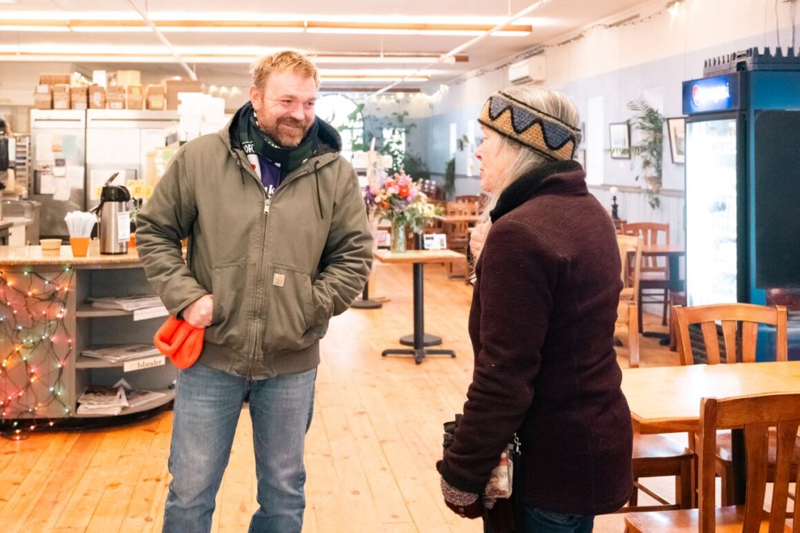 Graham Platner speaks with a woman.