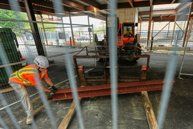 A worker moves a steel i-beam at the site of a construction of a housing project.
