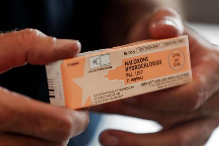 medic holds a box containing naloxone hydrochloride