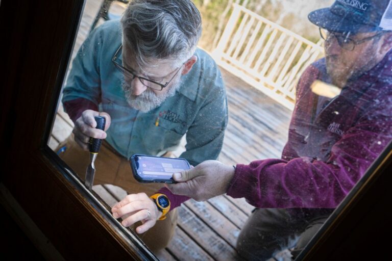 Technicians inspect a drafty back door