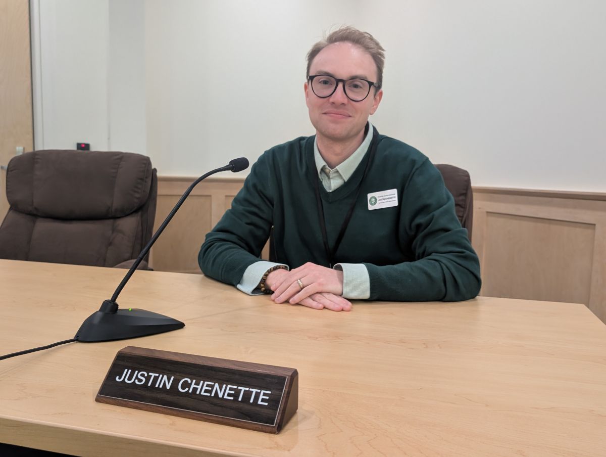 Justin Chenette poses for a photo while sitting in his commission seat