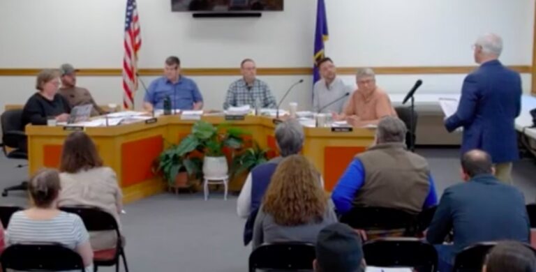 school board members listen to a speaker.