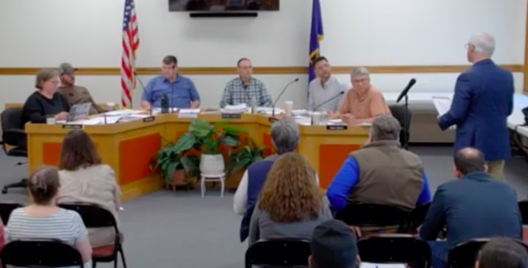 school board members listen to a speaker.