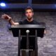 Travis Carey speaks during a church service.