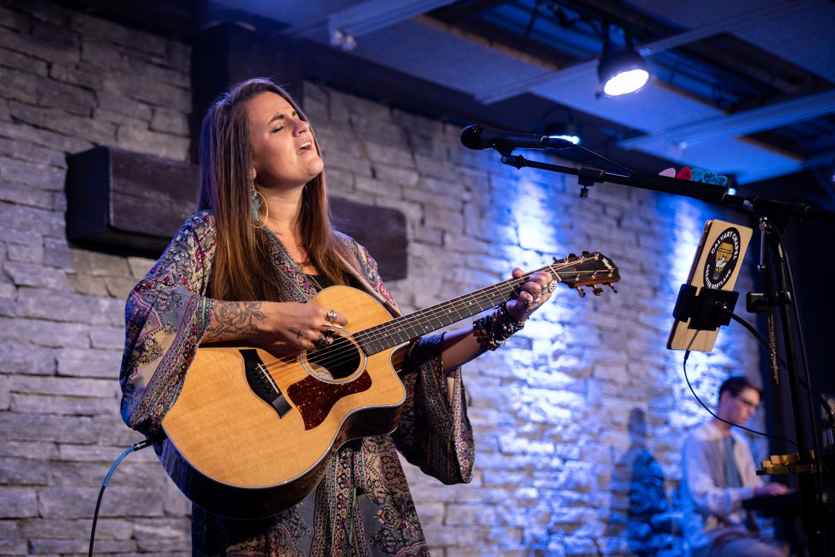 a woman plays guitar during a hymnal