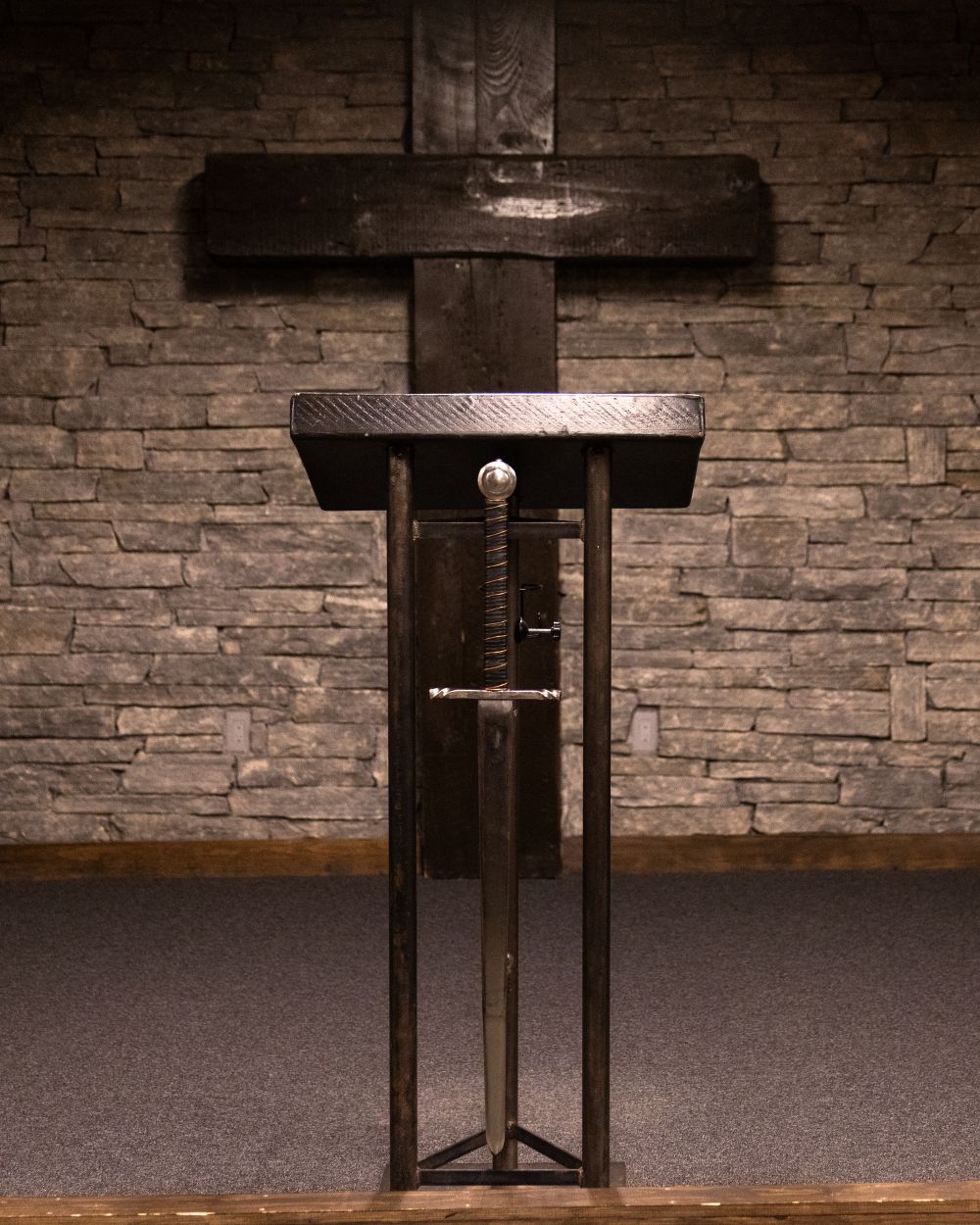 A sword attached to the front of a lectern.