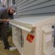 technician installing a cap to protect a heat pump