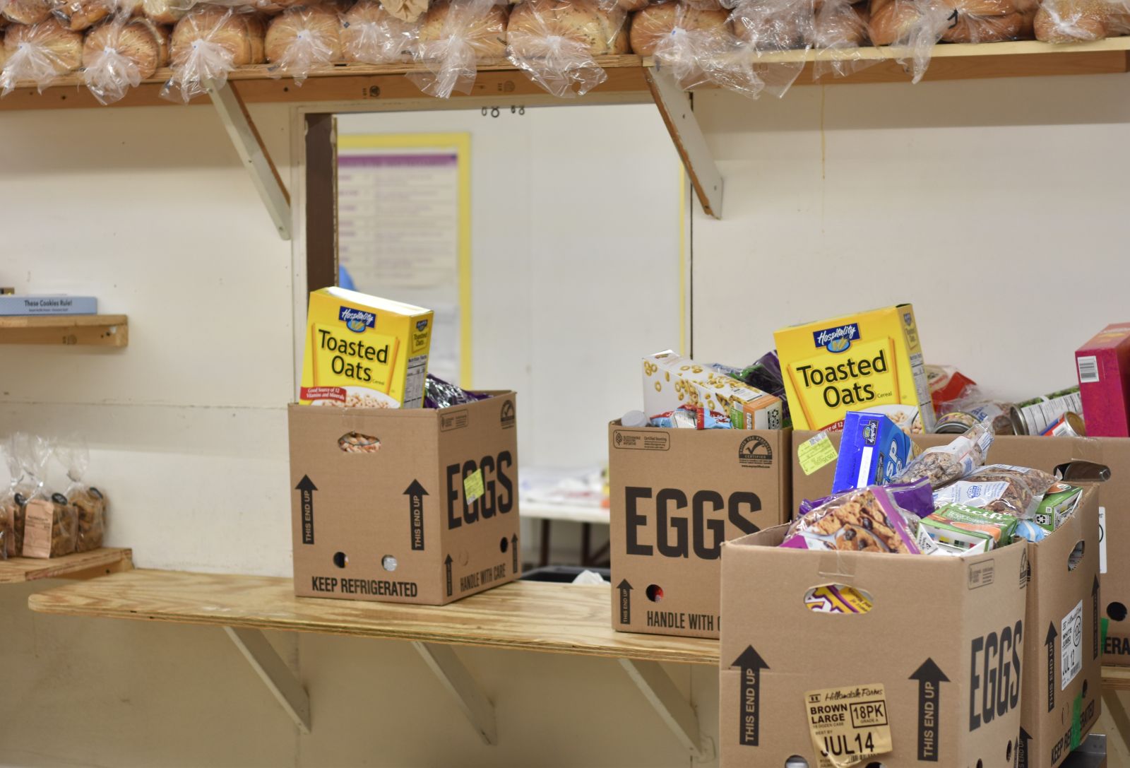 filled food pantry boxes sit on shelves.
