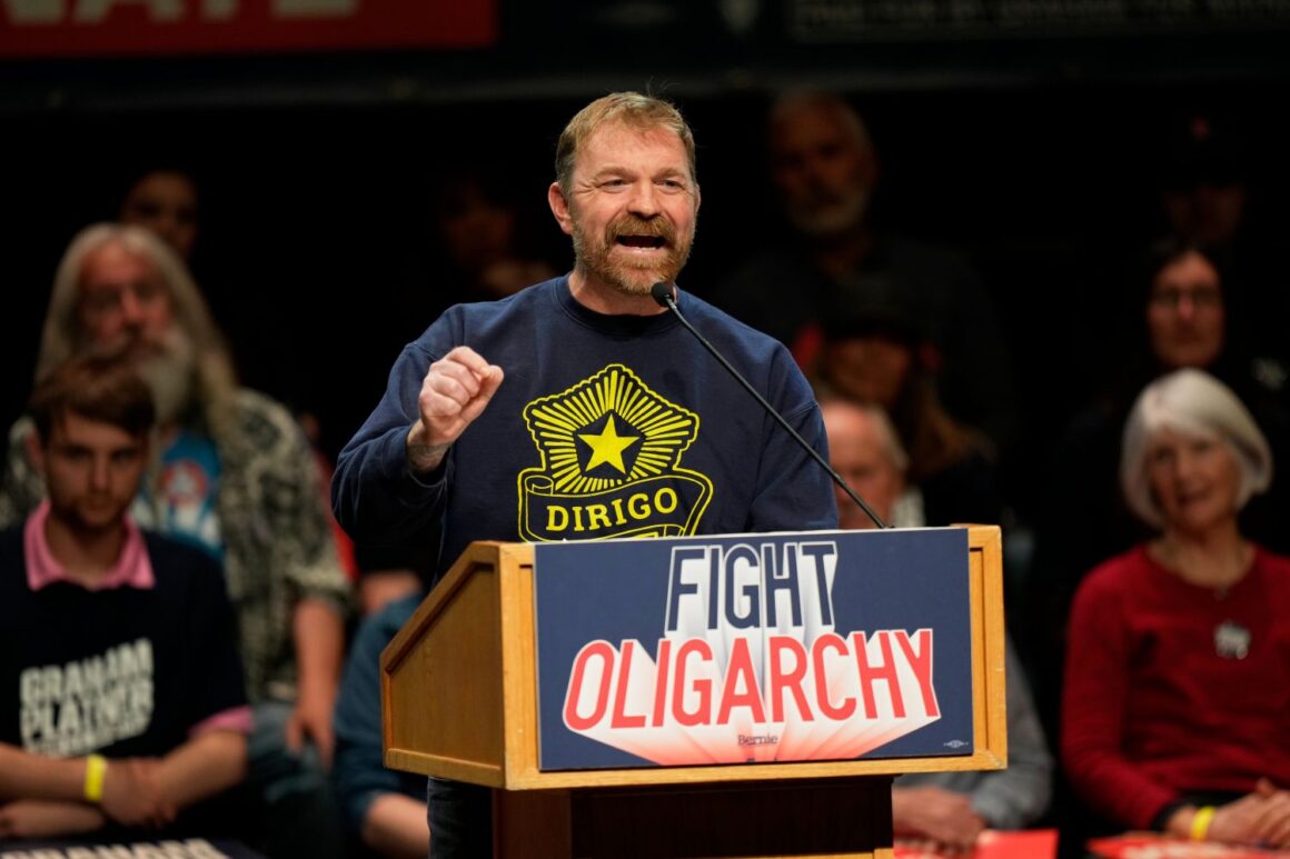 Graham Platner speaks at a podium during a campaign event.