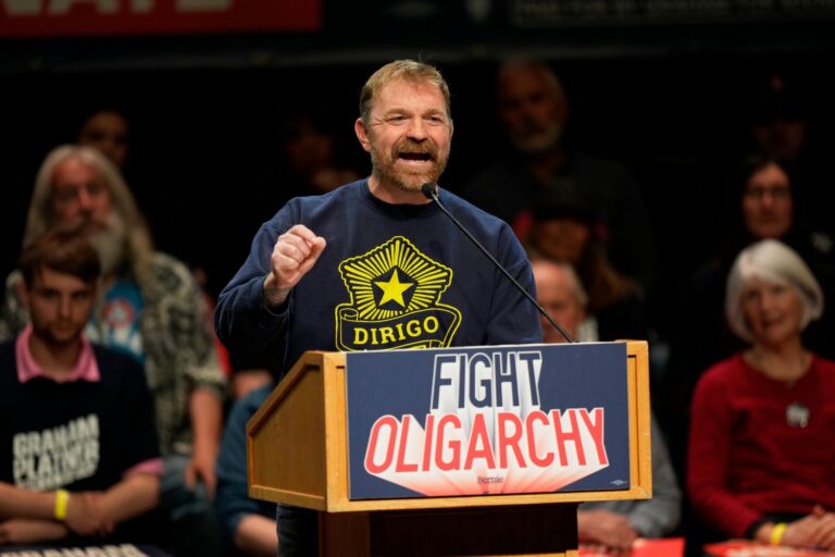 Graham Platner speaks at a podium during a campaign event.