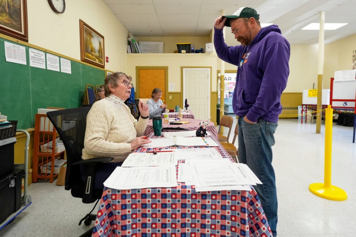 Graham Platner standing at a check-in table.