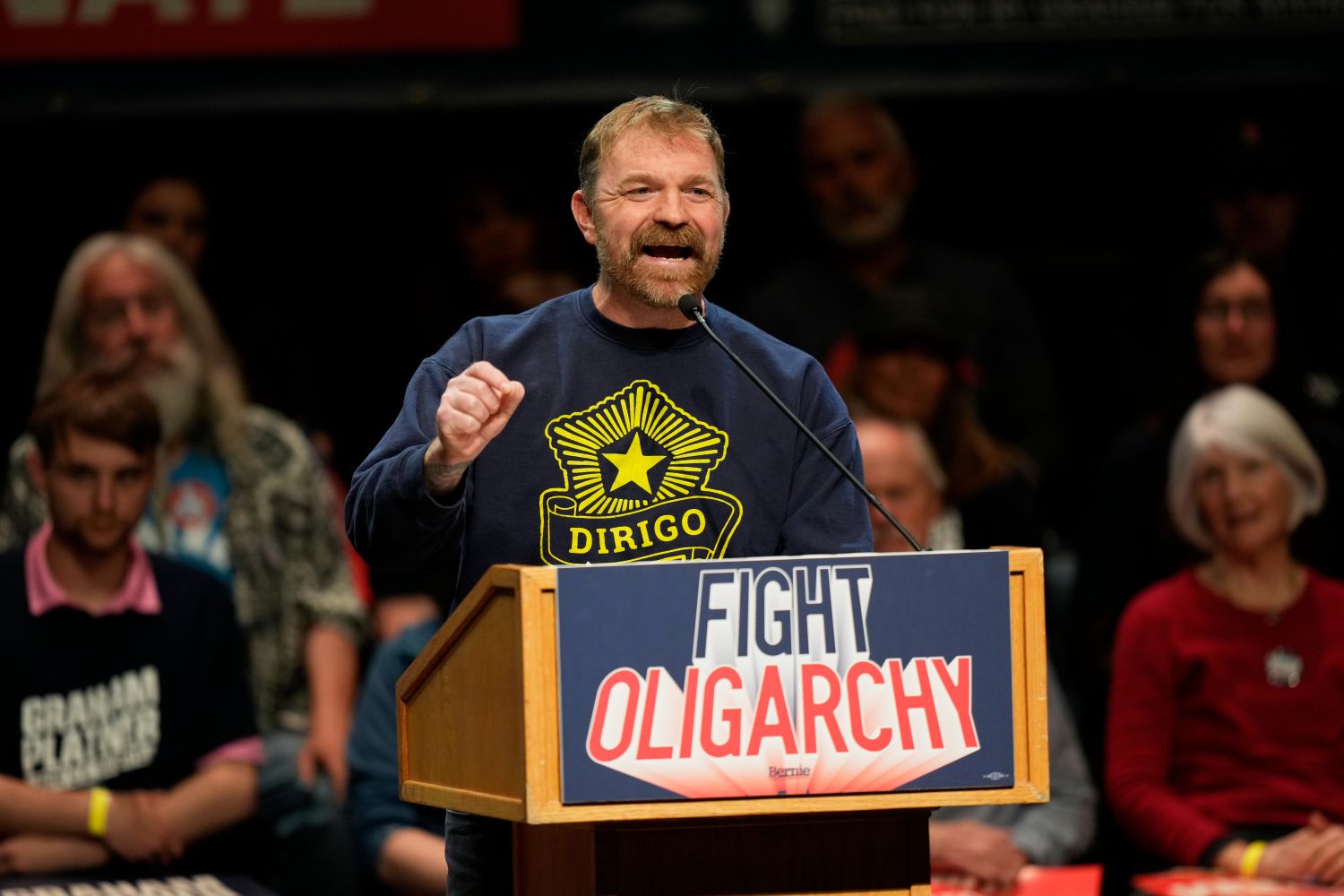 Graham Platner speaks at a podium during a campaign event.