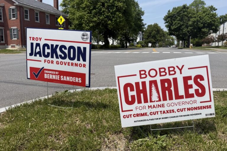 campaign yard signs for Troy Jackson and Bobby Charles seen at the edge of an intersection.