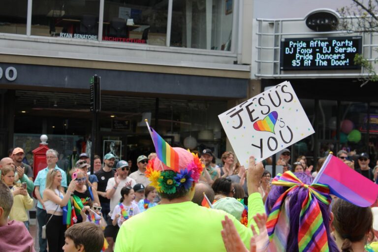 An individual holding a poster that reads Jesus hearts you.