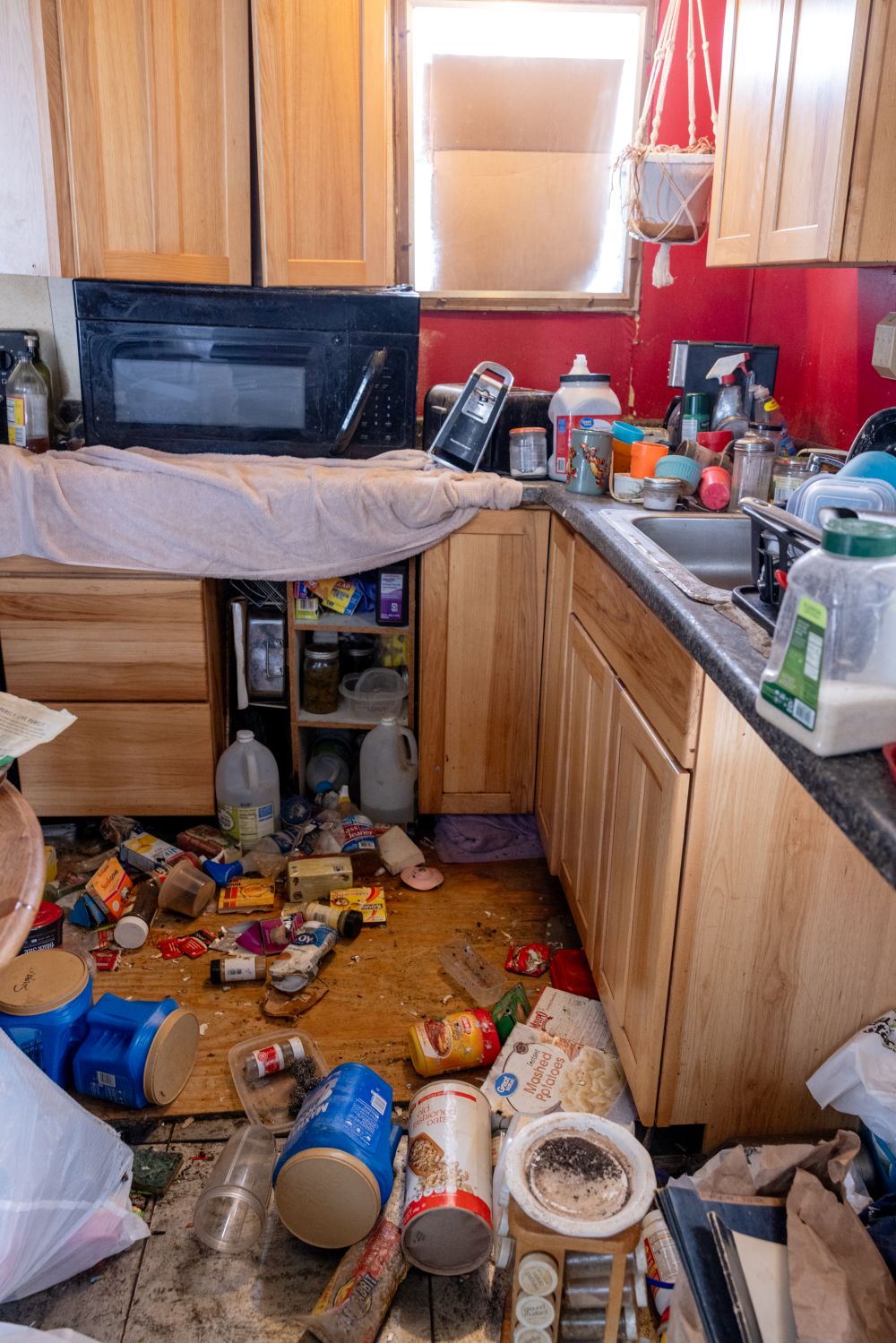 garbage scattered throughout the floor and countertops of a kitchen.