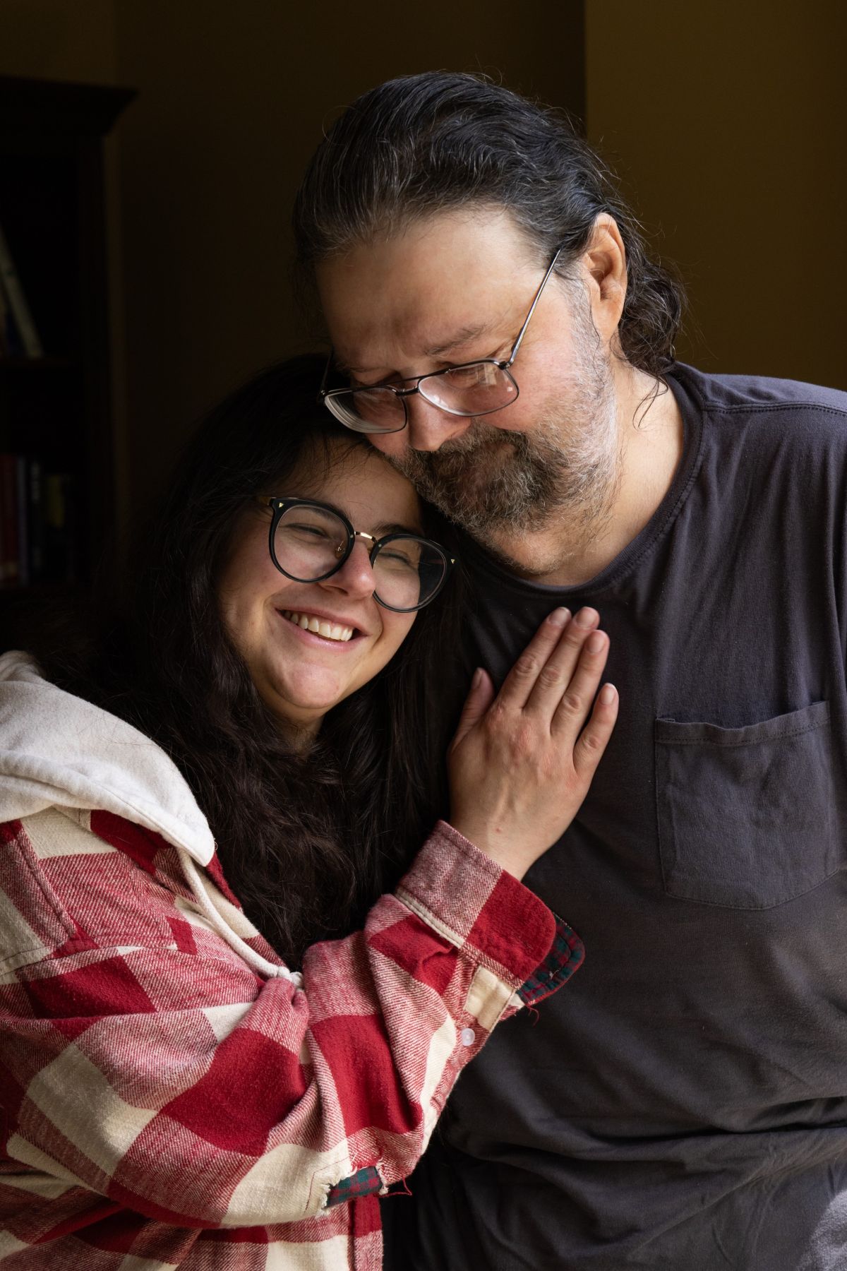 Christiana leans her head against her father's shoulder.