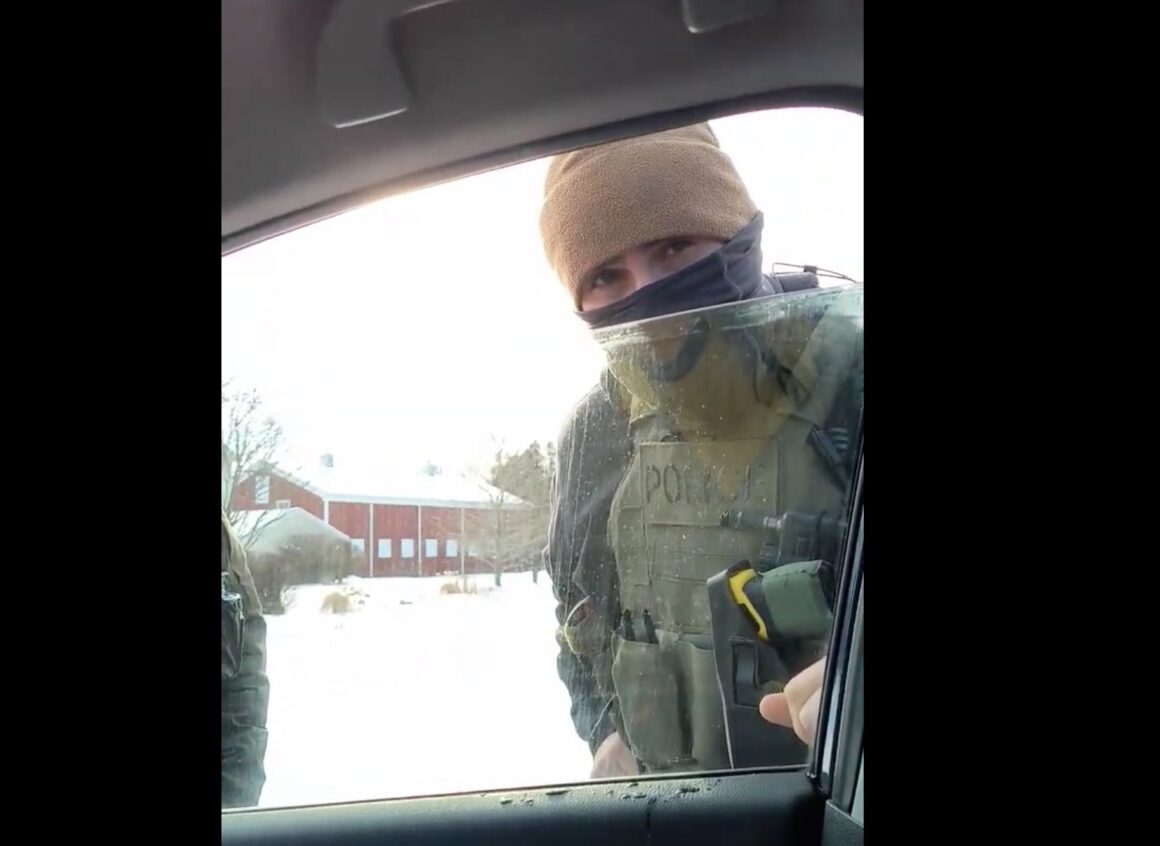 A screeshot from Peck's video shows an agent speaking to him through a car window.