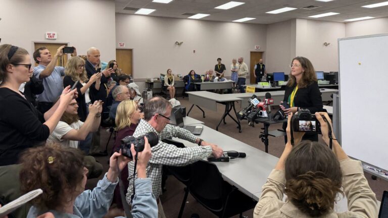 journalists gather around for a tabulation update.
