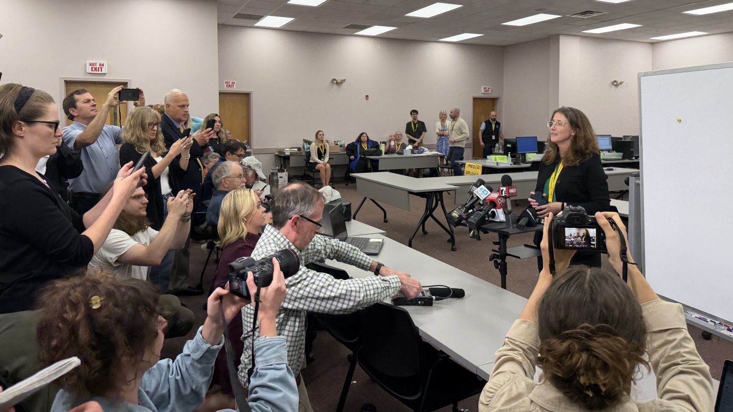 journalists gather around for a tabulation update.