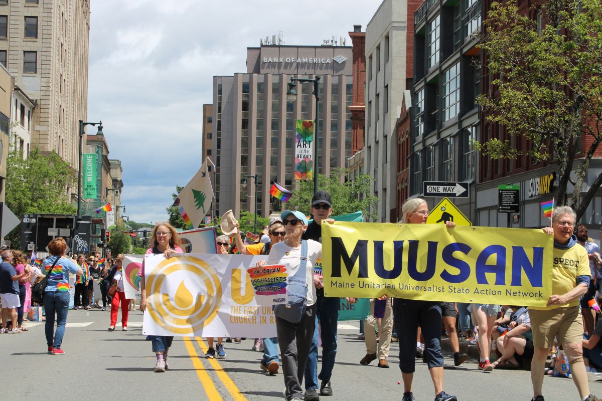 people walking with banners from Unitarian Universalist organizations