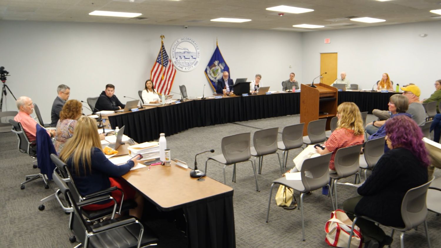 members of the crowd and members of the city council seen during the meeting.