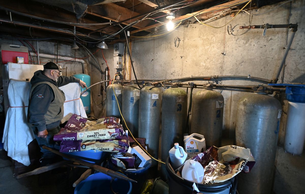 Fred Stone stands by the six tanks in his home filter system.