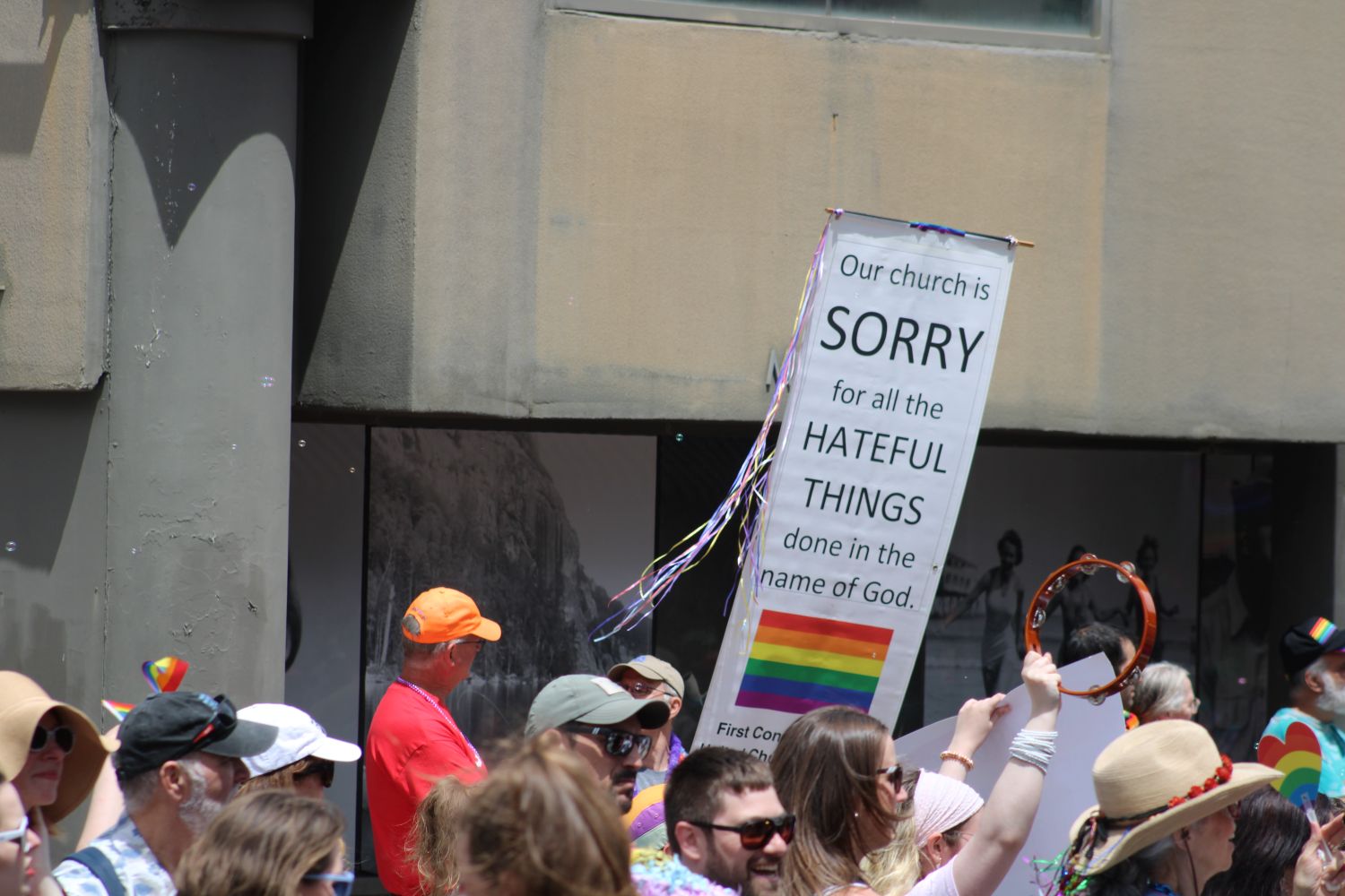 person holding a banner that reads our church is sorry for all the hateful things done in the name of God.