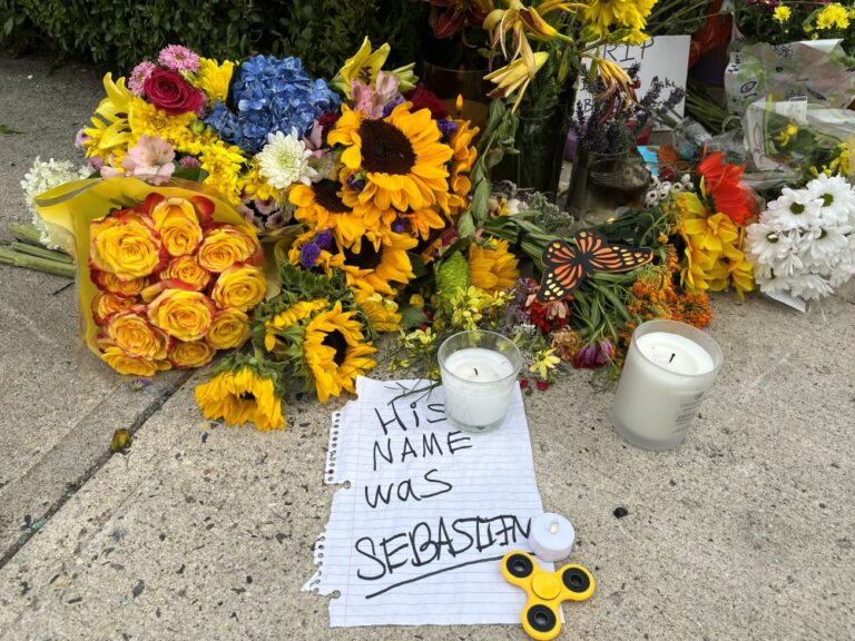 Yellow sunflowers and white candles adorn a memorial for. the man who was shot by immigration agents.