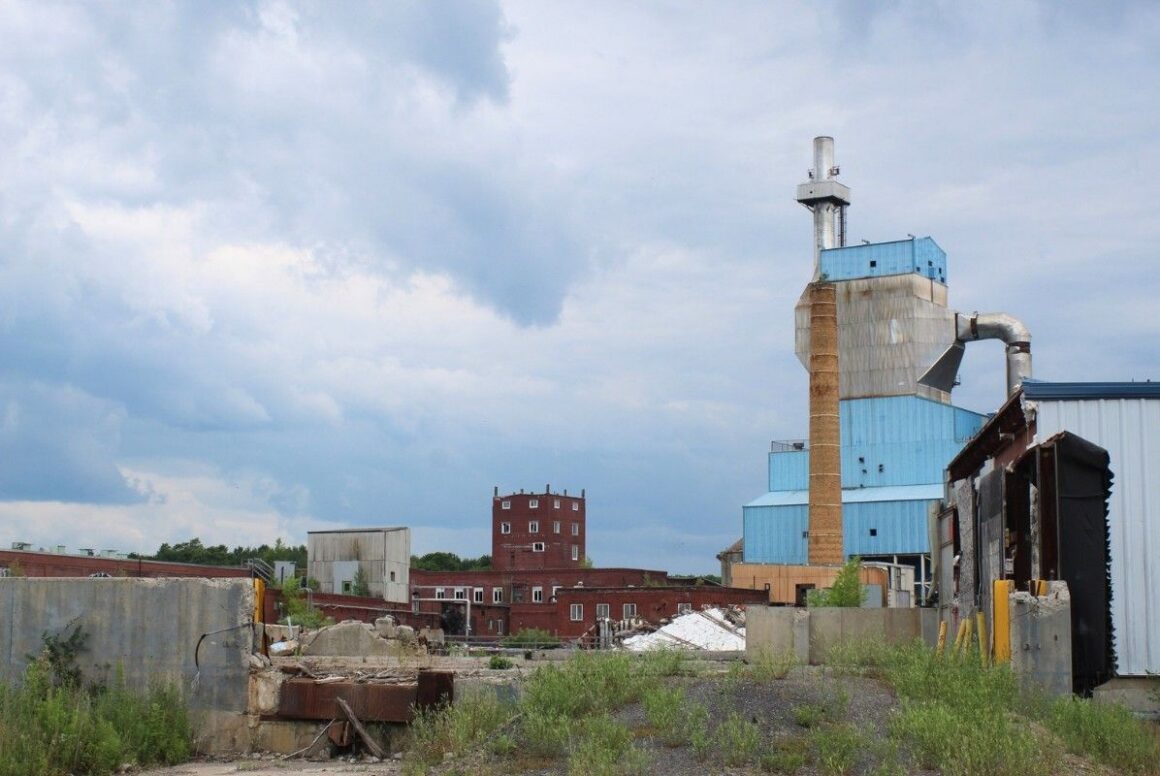smokestack rising over the dilapidated buildings