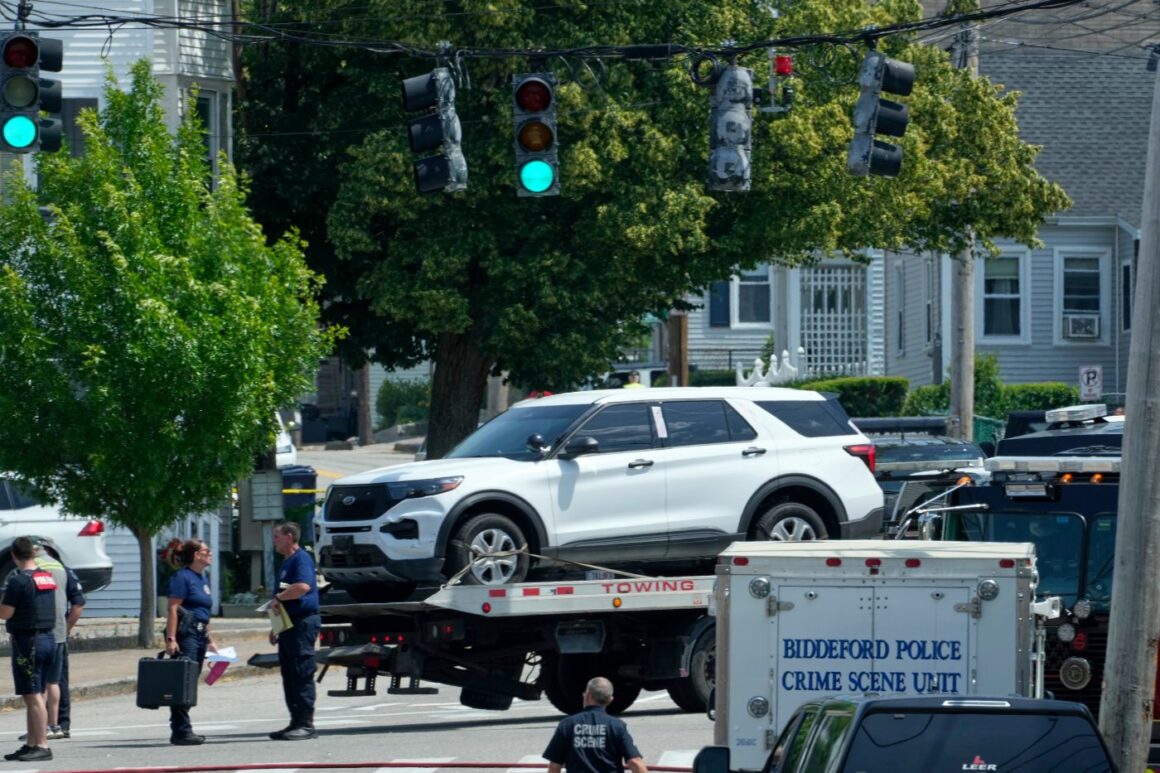 a white vehicle on the back of a flatbed truck.
