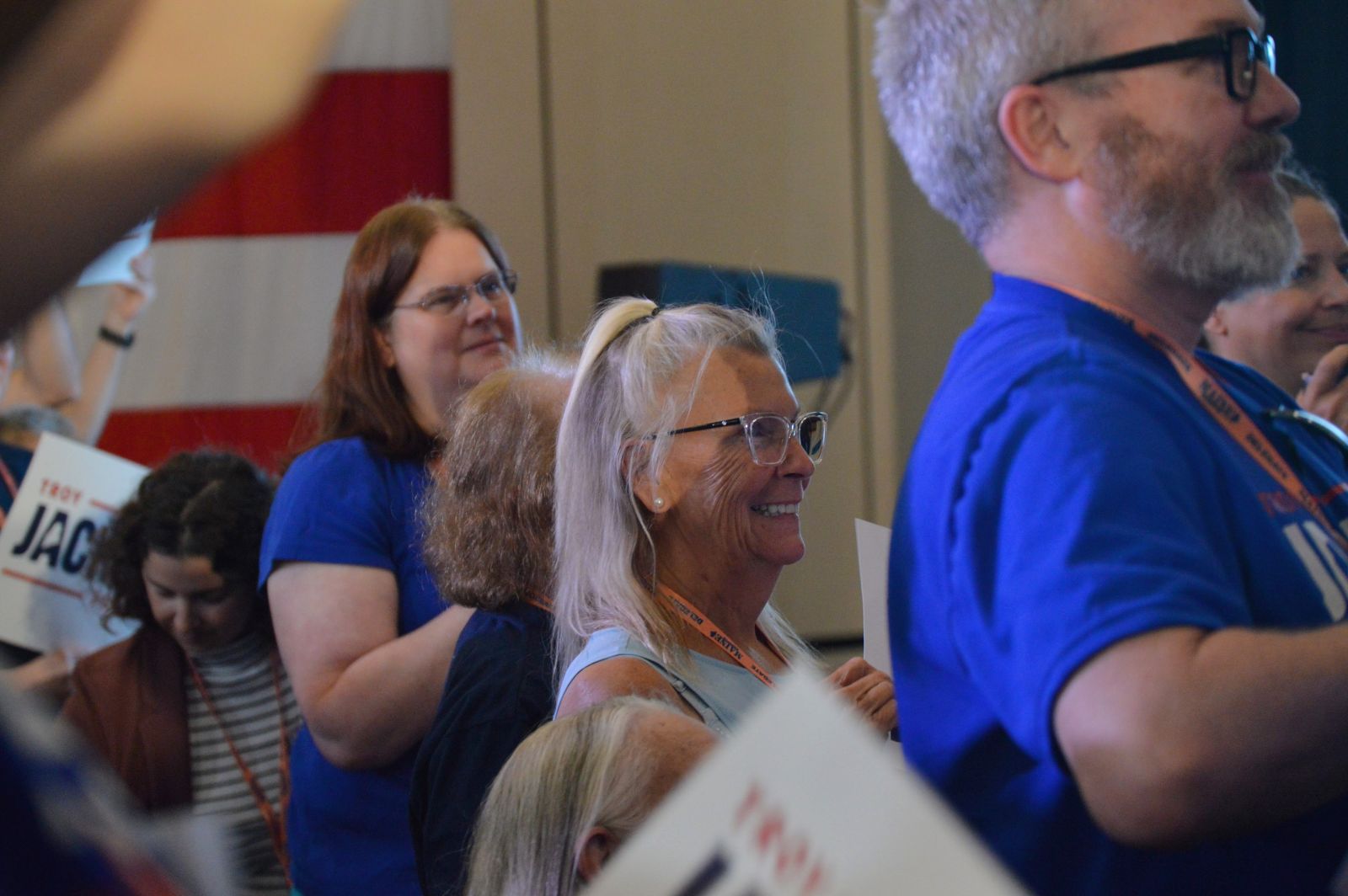 a woman smiles during the convention while listening to a speaker
