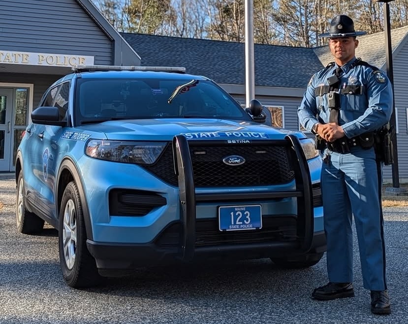 Trooper Jacob Murphy-Canto poses next to a cruiser.