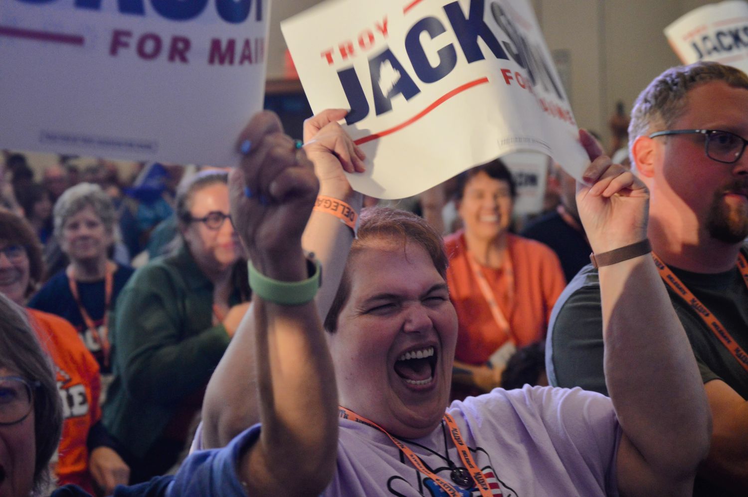 Lori Poland cheers while holding a sign in support of Troy Jackson.