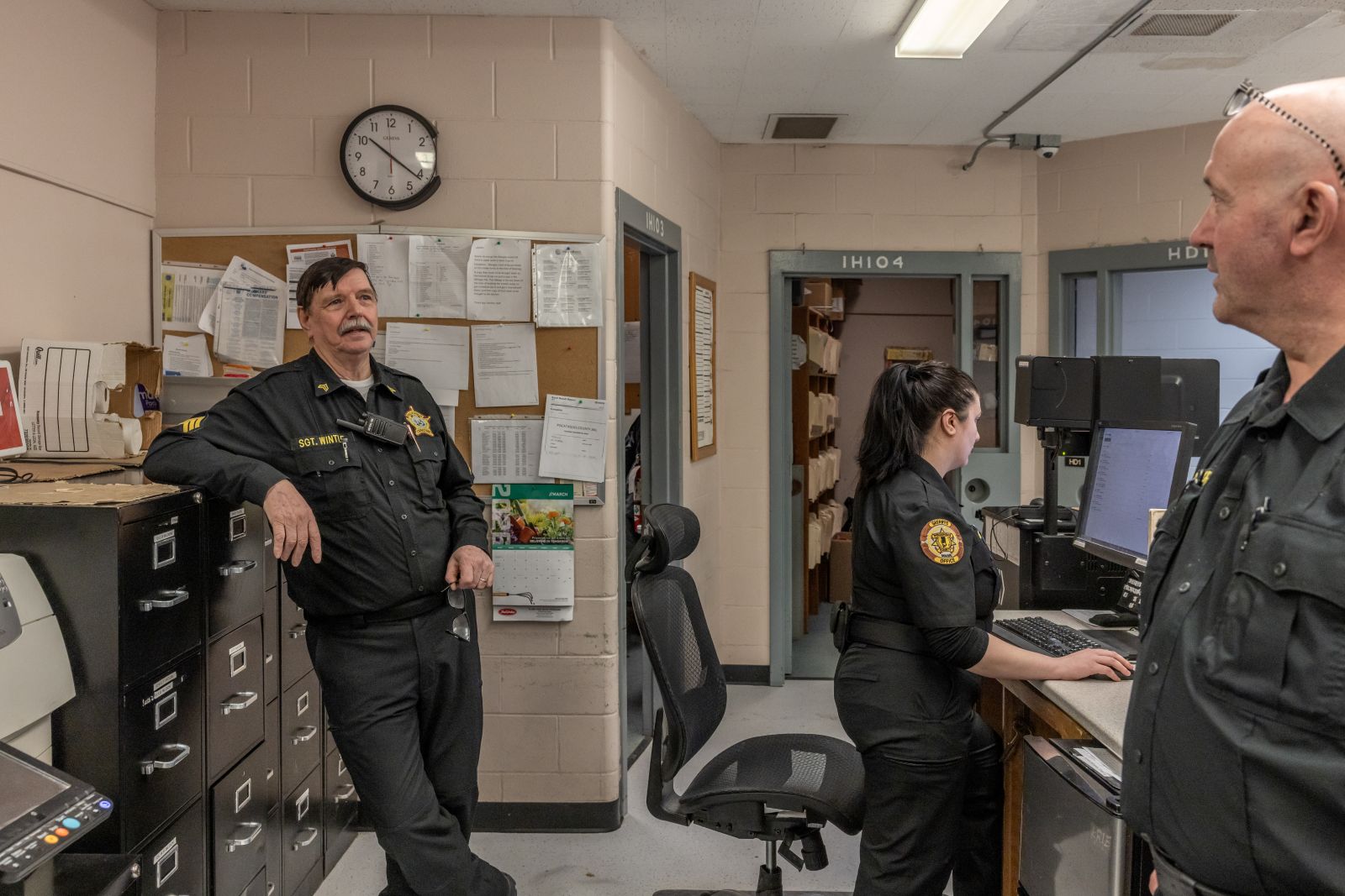 a trio of corrections officers engaged in conversation