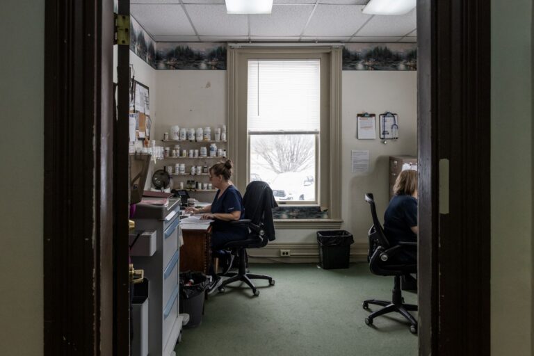 two women sitting at desks in an office.
