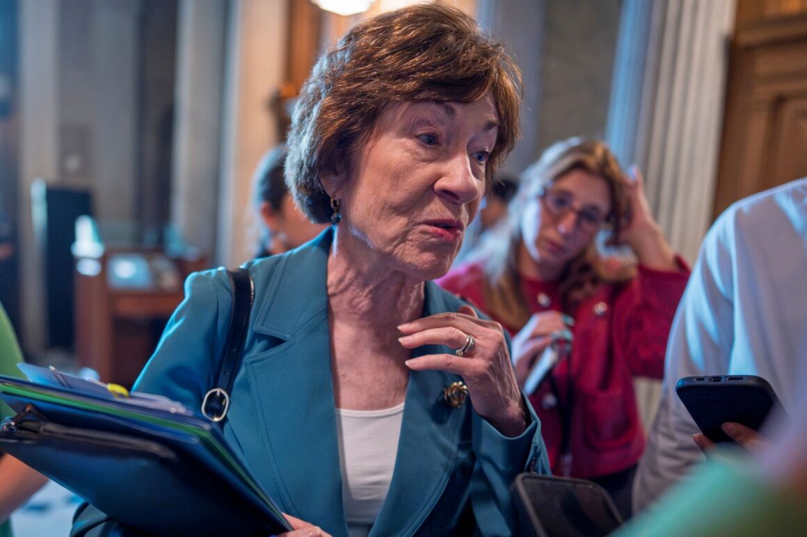 Susan Collins surrounded by and speaking with reporters.