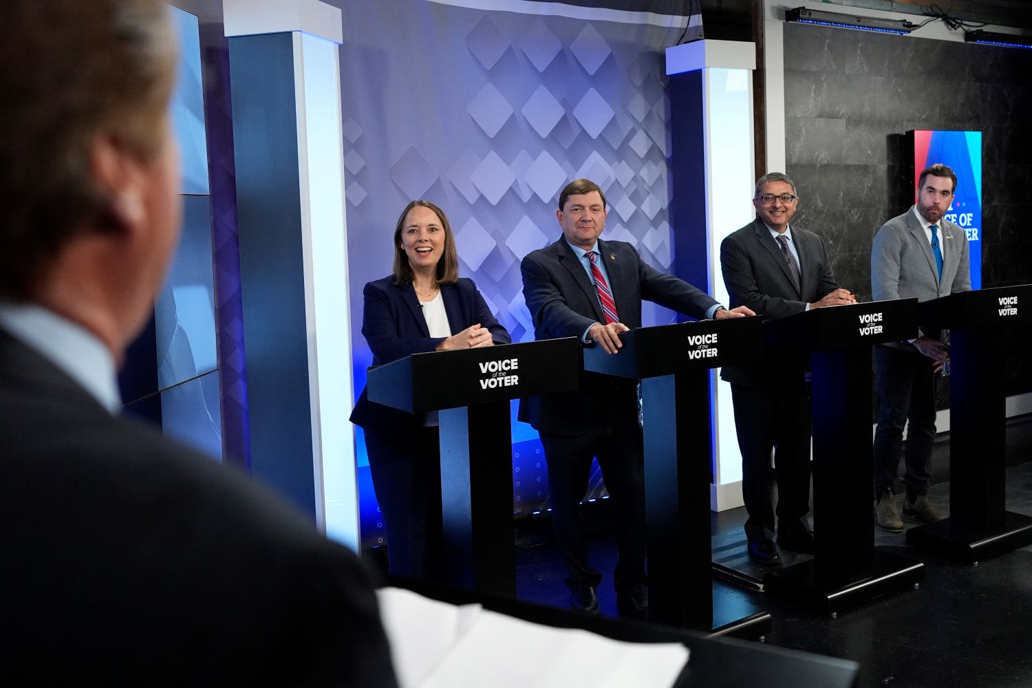Shenna Bellows, Troy Jackson, Nirav Shah and Jordan Wood stand at debate podiums.