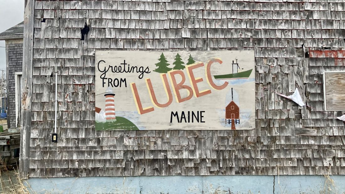 a sign on the side of a building that reads greetings from lubec, maine