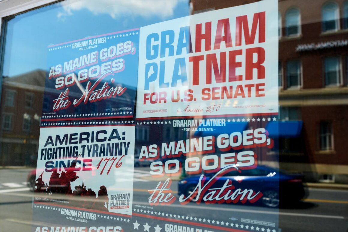 Campaign signs for Graham Platner in a window.