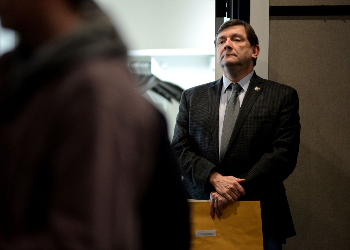 Troy Jackson stands while listening during a meeting.