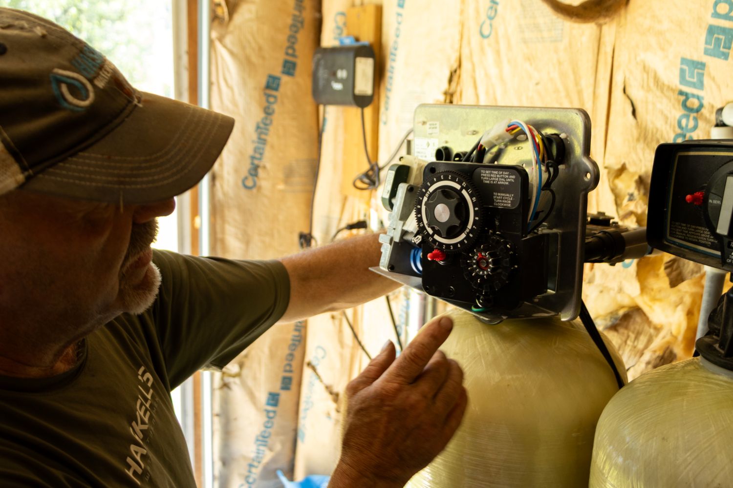 man adjusting timer on water filter.