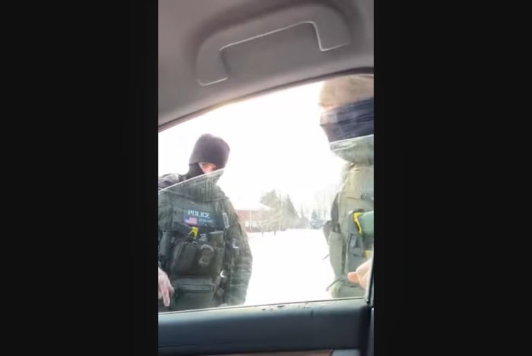 immigration agents seen talking to an individual inside a vehicle with the window slightly rolled down.