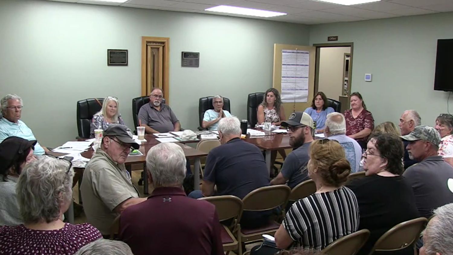 select board members listen to a speaker.
